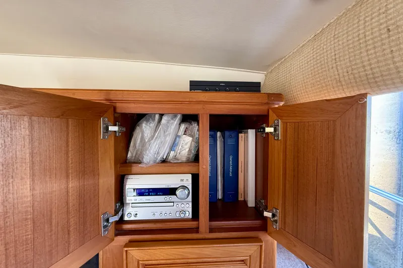 Slide: The Image of 1996 Egg Harbor 35 Sport Fisherman interior cabinet with stereo and manuals. - 77
