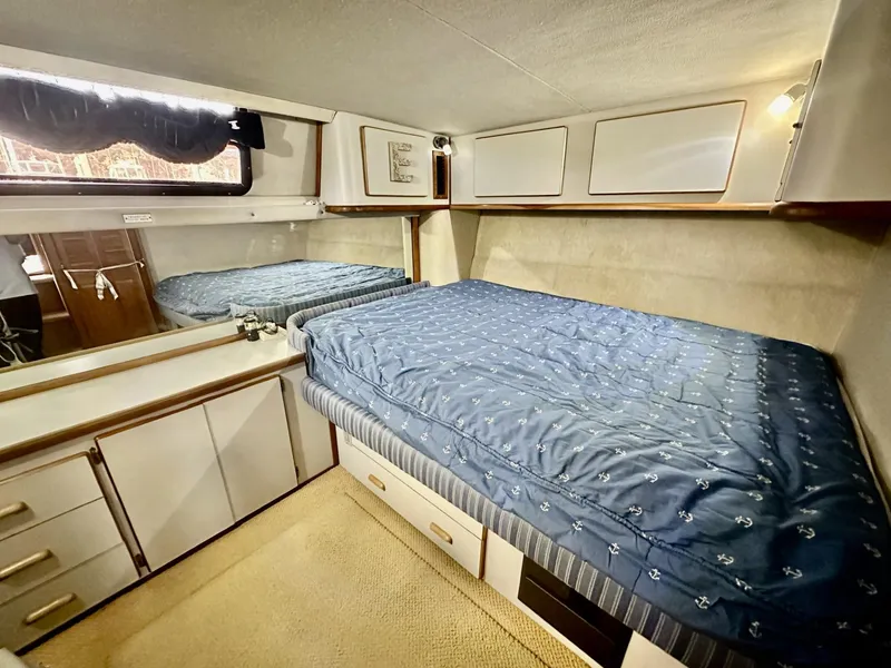 Slide: The Image of 1990 Sea Ray 380 Aft Cabin interior with bed and storage. - 12