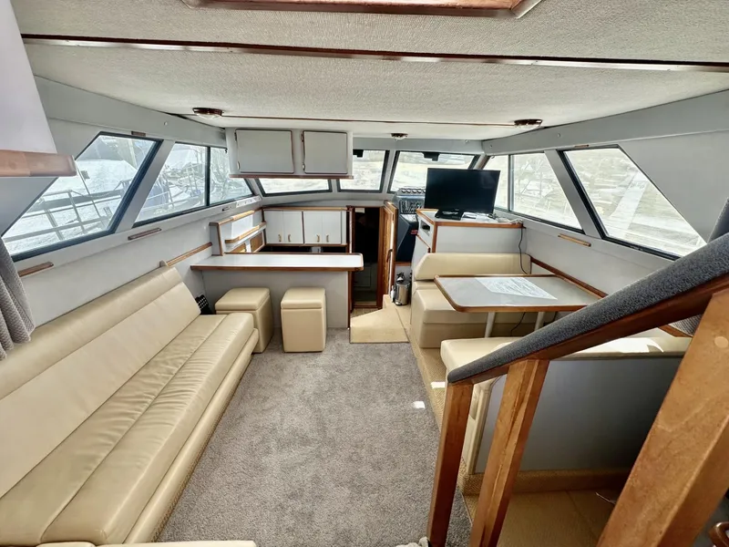Slide: The Image of Interior of a 1990 Sea Ray 380 Aft Cabin yacht with beige sofa and dining table. - 3