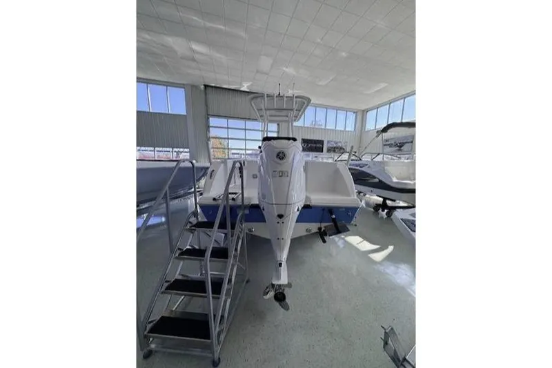 Slide: The Image of 2024 Aquasport 2200 Center Console boat displayed indoors with metal stairs. - 5