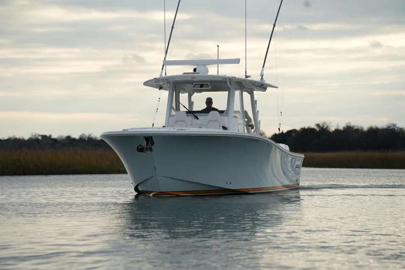 Slide: The Image of 2025 Regulator 37 boat cruising on calm water under a cloudy sky. - 10