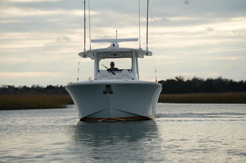 Slide: The Image of 2025 Regulator 37 boat cruising on calm water at sunset. - 11