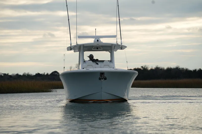 Slide: The Image of 2025 Regulator 37 boat cruising on calm waters under a cloudy sky. - 12