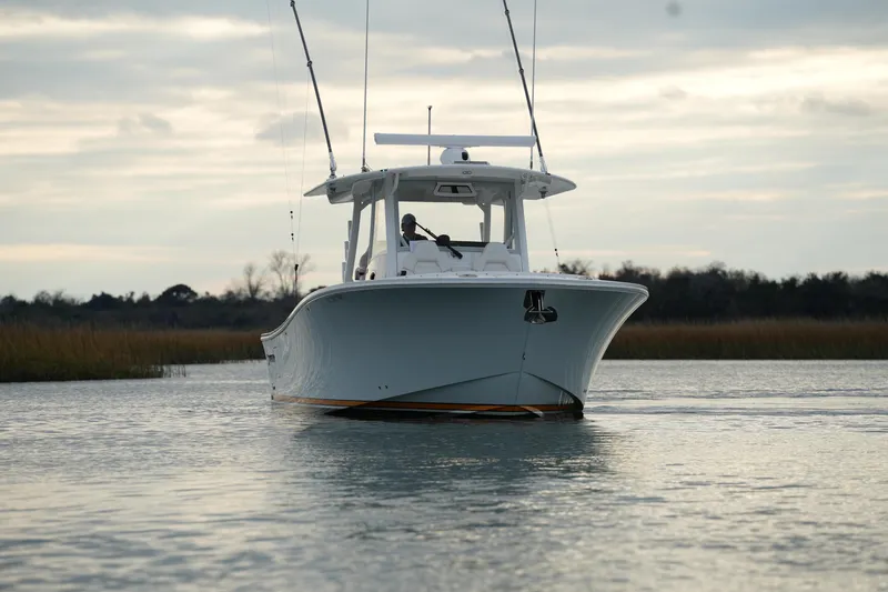 Slide: The Image of 2025 Regulator 37 boat cruising on calm water under a cloudy sky. - 13