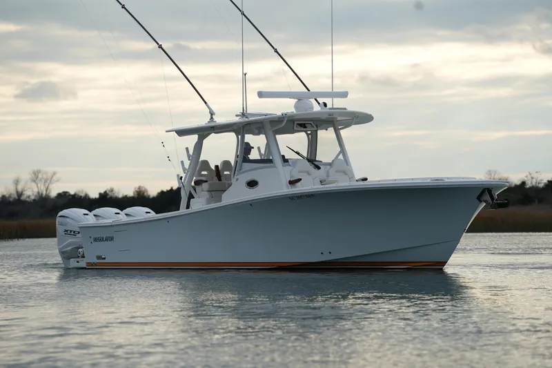 Slide: The Image of 2025 Regulator 37 boat on calm water, featuring sleek design and multiple outboard engines. - 15