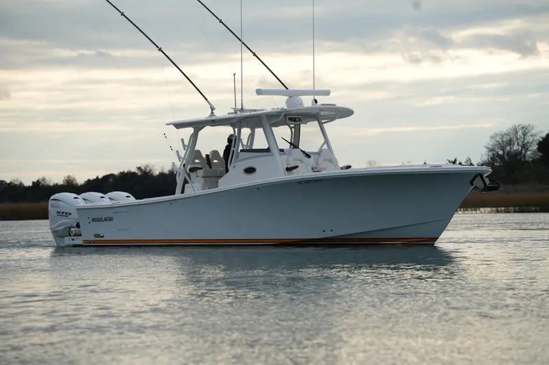 Slide: The Image of 2025 Regulator 37 boat on calm water with triple outboard engines. - 16