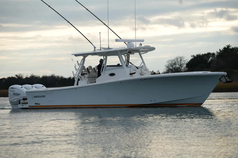 Slide: The Image of 2025 Regulator 37 boat on calm water, featuring dual outboard engines. - 17