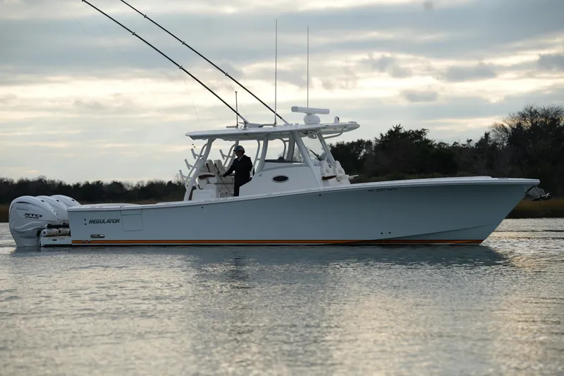 Slide: The Image of 2025 Regulator 37 boat on calm water, side view with dual engines. - 18