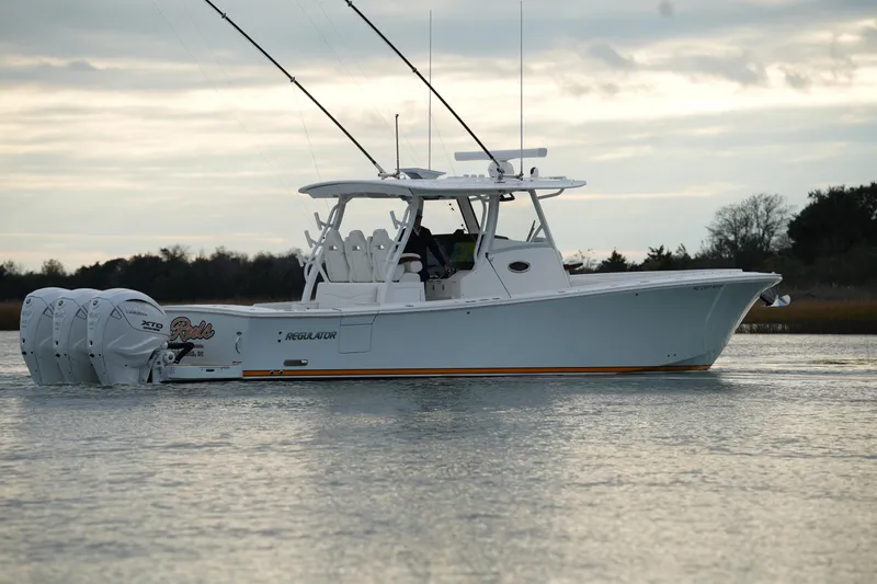 Slide: The Image of 2025 Regulator 37 boat on calm water, featuring triple outboard engines. - 20