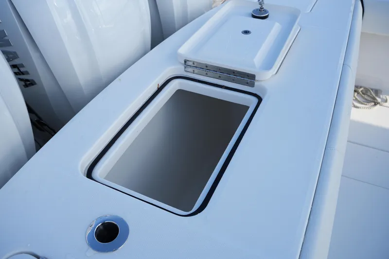 Slide: The Image of 2025 Regulator 37 boat with open storage compartment and sleek white design. - 28