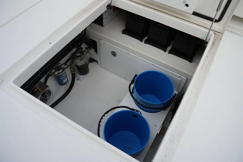 Slide: The Image of Open storage compartment on 2025 Regulator 37 boat with blue buckets and equipment. - 36