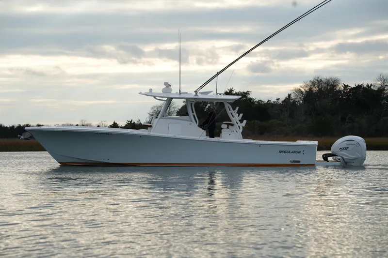 Slide: The Image of 2025 Regulator 37 boat on calm water, side view, overcast sky. - 4