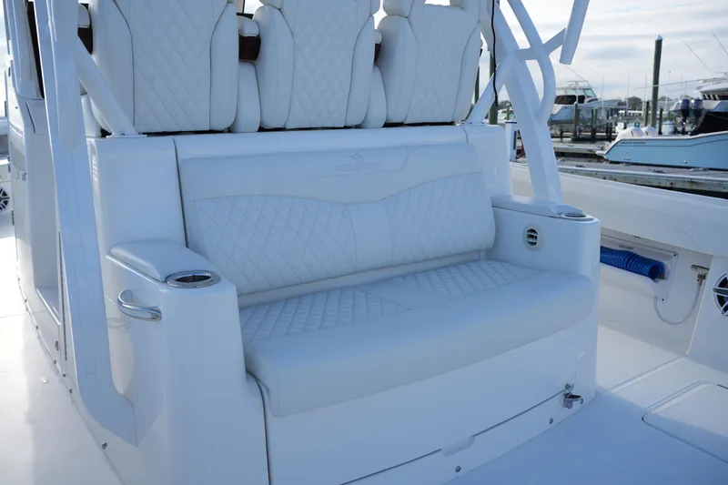 Slide: The Image of Luxurious seating on 2025 Regulator 37 boat, featuring white quilted upholstery and cup holders. - 43