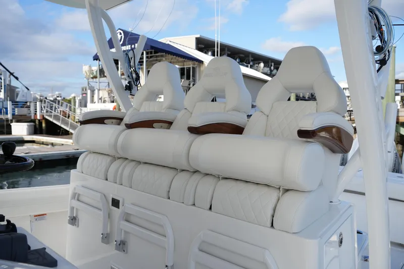 Slide: The Image of Luxurious seating on 2025 Regulator 37 boat, featuring white leather and wood accents. - 46
