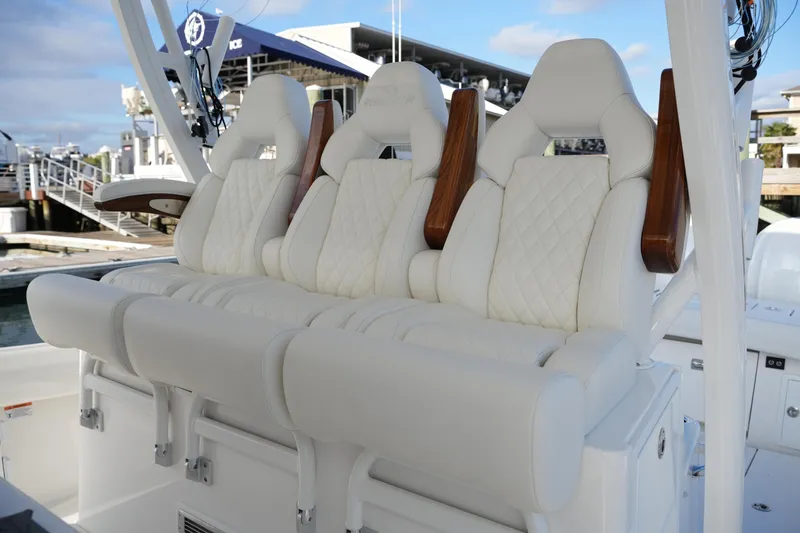 Slide: The Image of Luxurious seating on 2025 Regulator 37 boat, featuring elegant white upholstery and wooden accents. - 47