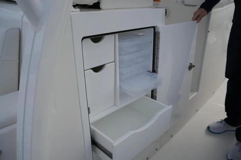 Slide: The Image of 2025 Regulator 37 boat storage compartment with open drawers and tackle boxes. - 51
