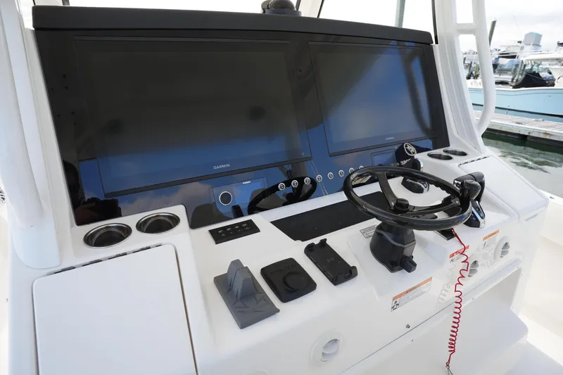 Slide: The Image of 2025 Regulator 37 boat helm with dual Garmin displays and steering wheel. - 52