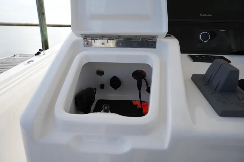 Slide: The Image of Open storage compartment on 2025 Regulator 37 boat, featuring electronic connections and accessories. - 56
