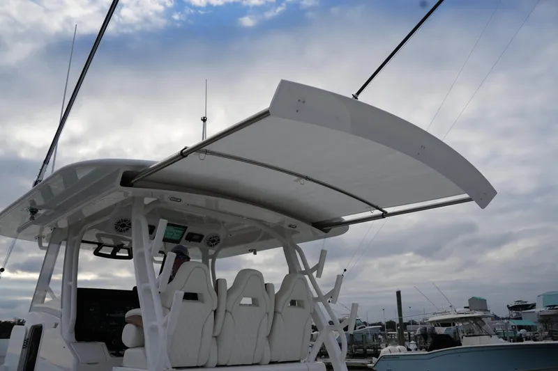 Slide: The Image of 2025 Regulator 37 boat with sleek design and modern seating under cloudy sky. - 64