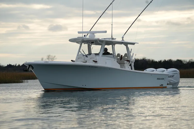 Slide: The Image of 2025 Regulator 37 boat on calm water, featuring dual outboard engines. - 7
