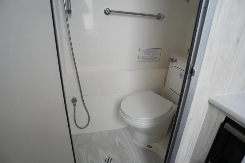 Slide: The Image of 2025 Regulator 37 boat bathroom with toilet and showerhead. - 74