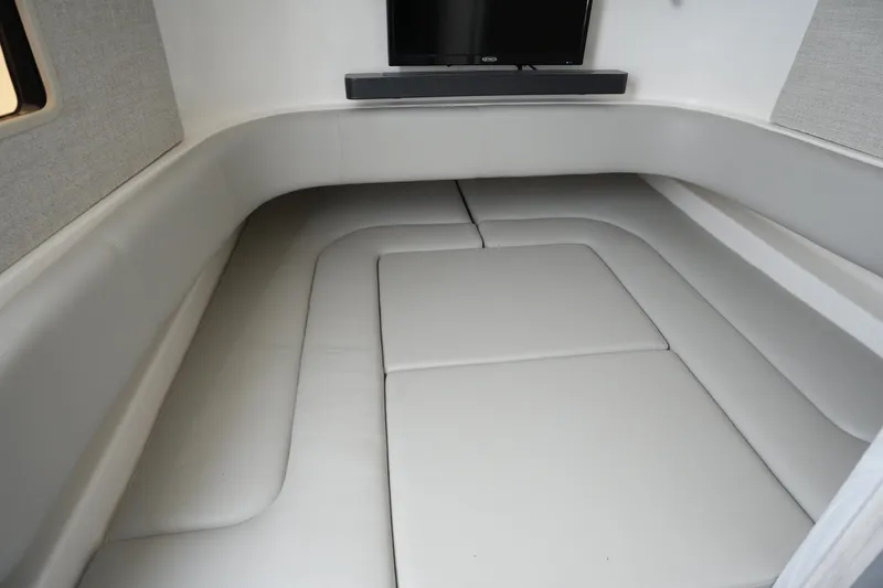 Slide: The Image of Interior of 2025 Regulator 37 boat with cushioned seating and a mounted TV. - 75