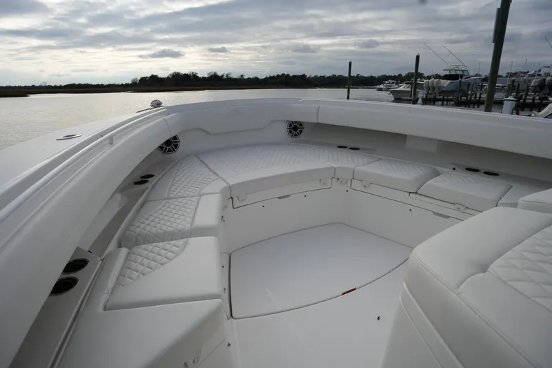 Slide: The Image of Luxurious seating area on 2025 Regulator 37 boat, featuring quilted upholstery and cup holders. - 78