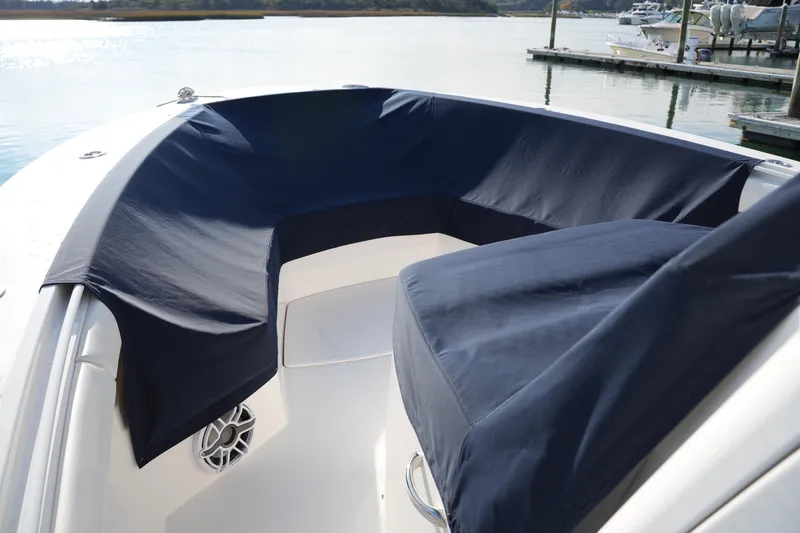 Slide: The Image of 2025 Regulator 37 boat with navy blue seat covers at a marina. - 85