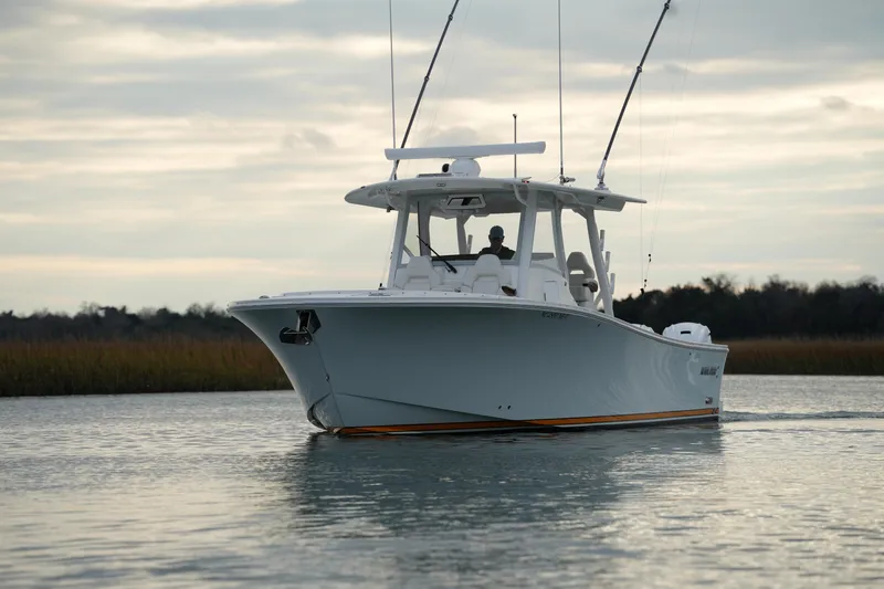 Slide: The Image of 2025 Regulator 37 boat cruising on calm water under cloudy sky. - 9