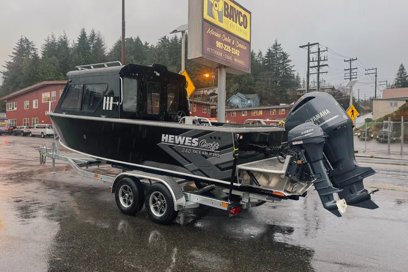 Slide: The Image of 2026 Hewescraft 240 Ocean Pro ET HT boat on trailer in rainy parking lot. - 3