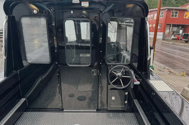 Slide: The Image of 2026 Hewescraft 240 Ocean Pro ET HT boat interior with steering wheel and cabin view. - 9