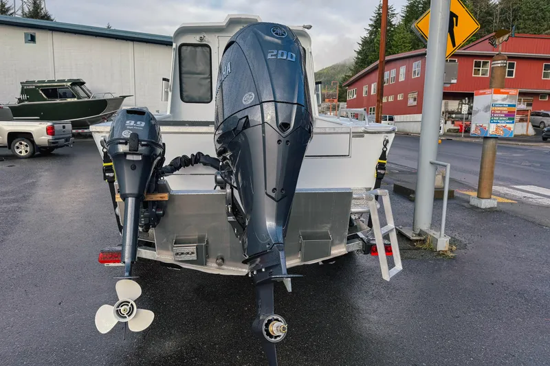 Slide: The Image of 2026 Hewescraft 210 Sea Runner ET HT with dual outboard motors in a parking lot. - 3