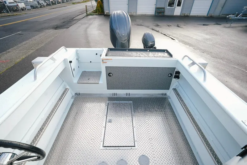 Slide: The Image of 2026 Hewescraft 210 Sea Runner ET HT boat interior with diamond plate flooring and storage compartments. - 9