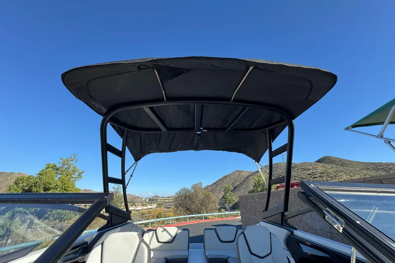 Slide: The Image of 2023 Yamaha Boats AR250 with canopy, scenic mountain backdrop, clear blue sky. - 15