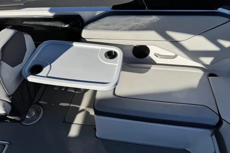 Slide: The Image of 2023 Yamaha AR250 boat interior with seating and a table featuring cup holders. - 20