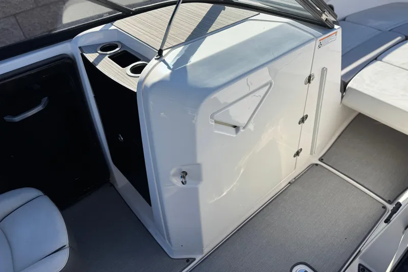 Slide: The Image of 2023 Yamaha Boats AR250 interior with storage compartment and cup holders. - 23