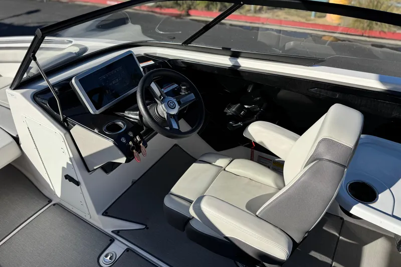 Slide: The Image of 2023 Yamaha Boats AR250 cockpit with steering wheel and touchscreen display. - 25