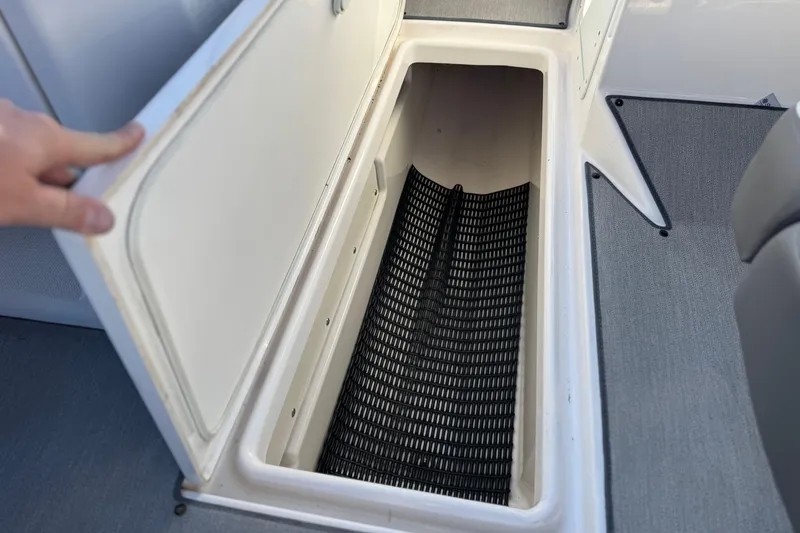 Slide: The Image of 2023 Yamaha Boats AR250 storage compartment with open hatch, showcasing interior space. - 34