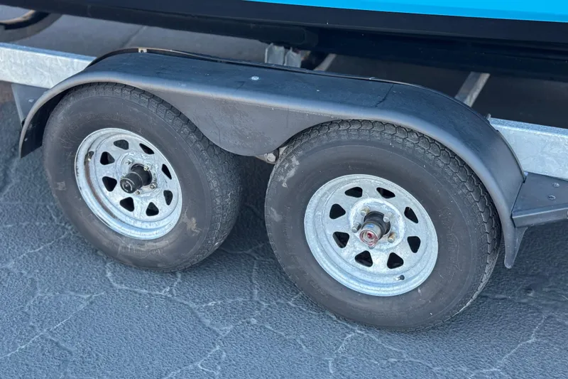 Slide: The Image of Trailer wheels for 2023 Yamaha Boats AR250 on textured pavement. - 35