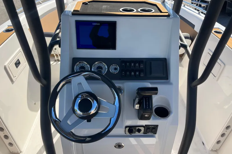 Slide: The Image of 2024 Starcraft SVX 231 OB CC boat dashboard with steering wheel and control panel. - 10
