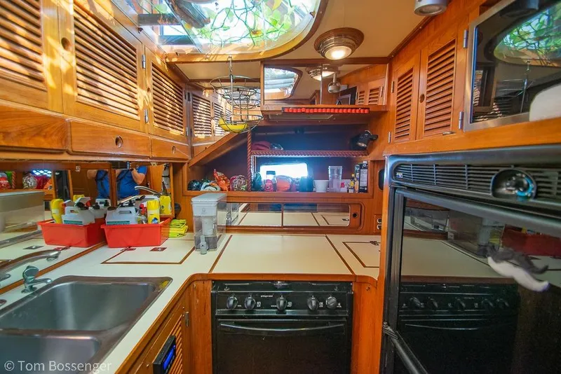 Slide: The Image of 1985 Spindrift 40 yacht kitchen with wooden cabinets, stove, and sink. - 11