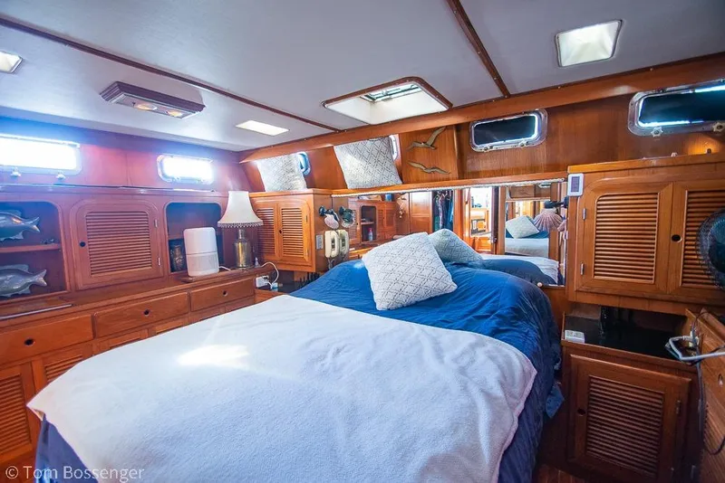 Slide: The Image of Cozy cabin interior of 1985 Spindrift 40 yacht with wooden furnishings and blue bedding. - 14