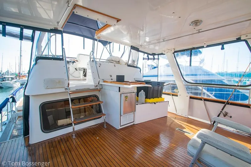 Slide: The Image of Interior view of 1985 Spindrift 40 yacht with wooden flooring and marina backdrop. - 24