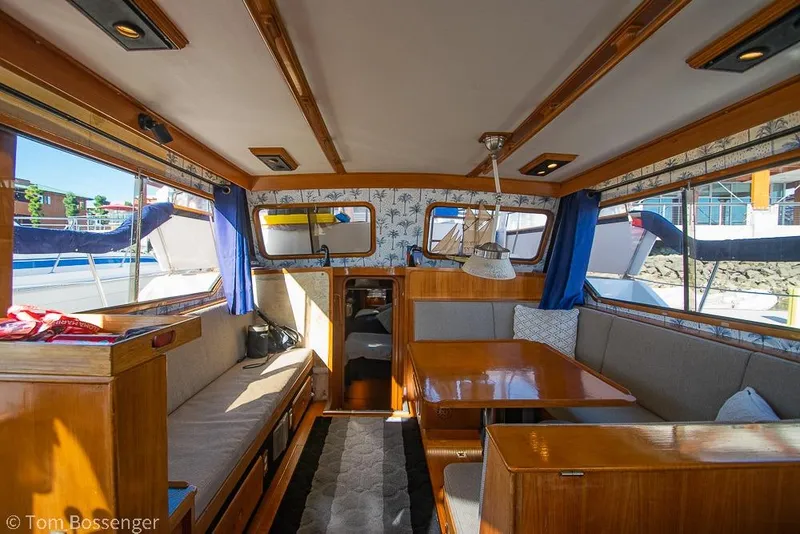 Slide: The Image of Interior of a 1985 Spindrift 40 yacht with wooden furnishings and blue curtains. - 4