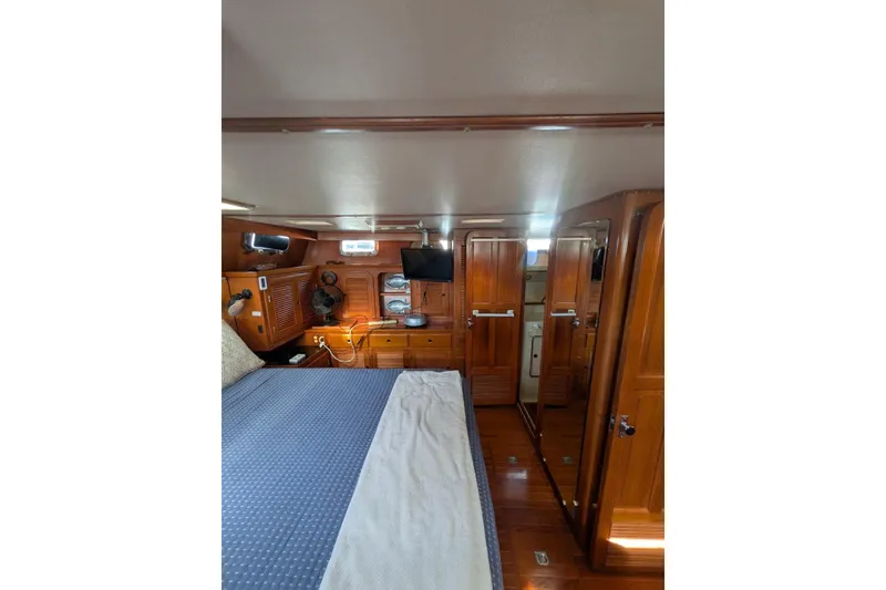 Slide: The Image of Interior of 1985 Kha Shing Spindrift 40 yacht with wooden cabinetry and cozy bedding. - 21