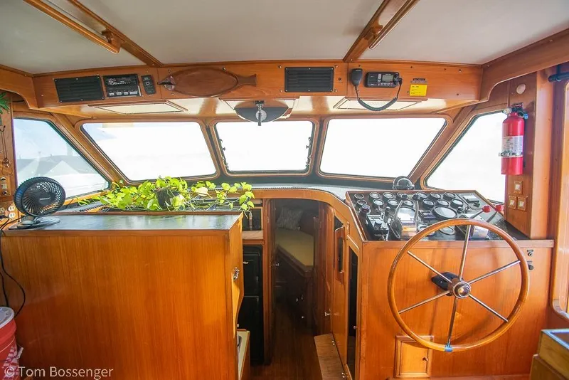 Slide: The Image of Interior of 1985 Spindrift 40 boat with wooden helm, gauges, and potted plant. - 8