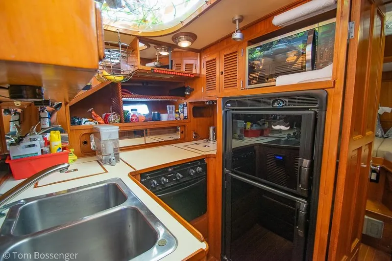Slide: The Image of Interior of 1985 Spindrift 40 yacht kitchen with wooden cabinetry and modern appliances. - 9