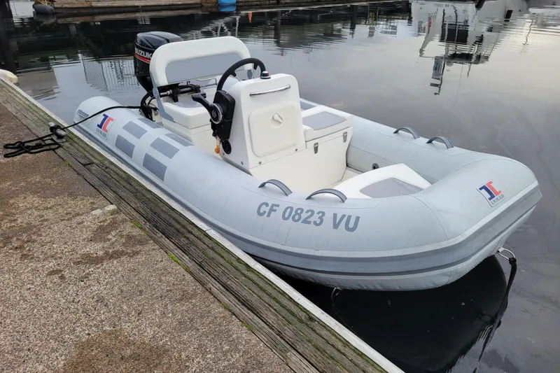 The Image of 2020 Inmar 330R-YS inflatable boat docked, featuring a Suzuki outboard motor. - 0
