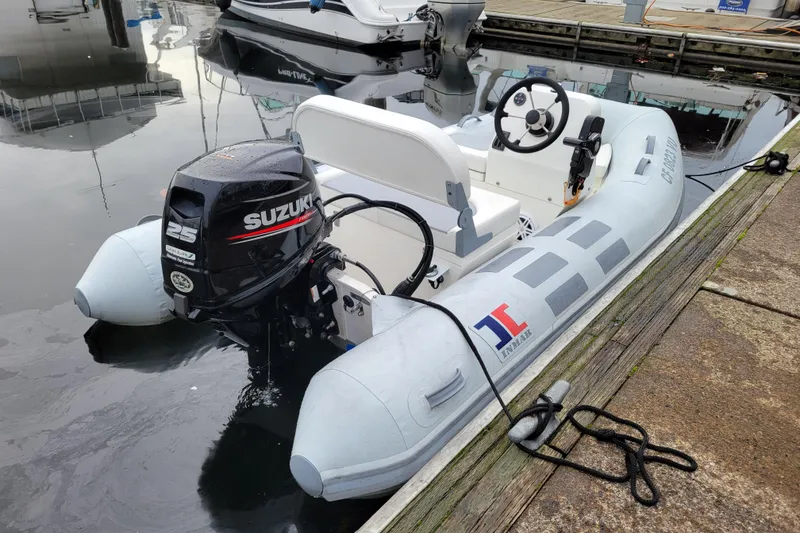 Slide: The Image of 2020 Inmar 330R-YS inflatable boat with Suzuki 25 outboard motor docked at marina. - 2