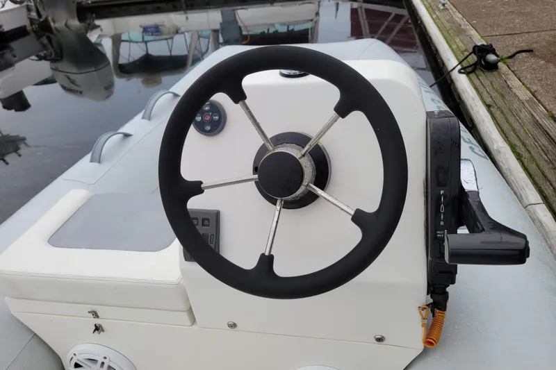 Slide: The Image of Steering wheel of a 2020 Inmar 330R-YS boat, docked by the water. - 5